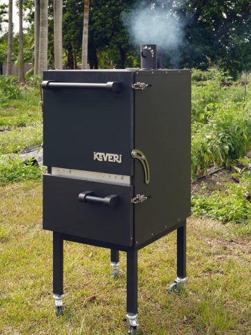 A black smoker emitting smoke, showcasing a dynamic display of billowing gray clouds against a contrasting background.